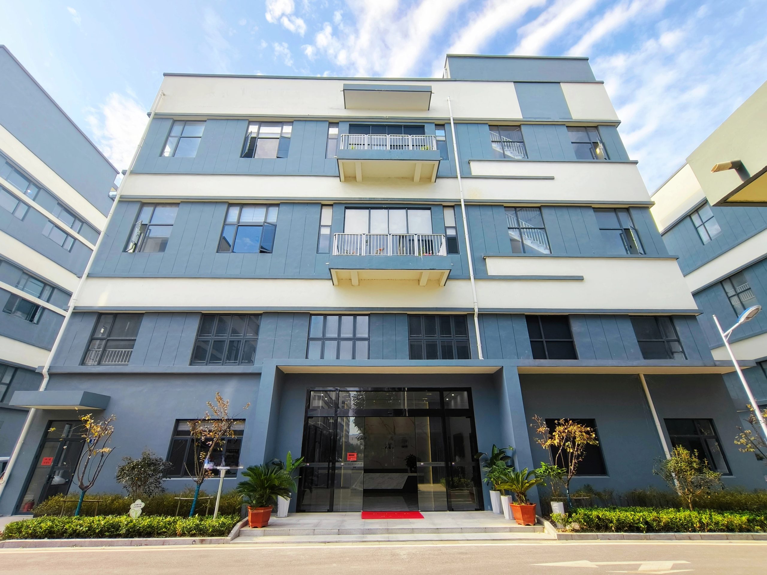 XLUIG (Xinluan United) modern factory building exterior, showcasing the Industry-Trade Integrated manufacturing base for industrial components.